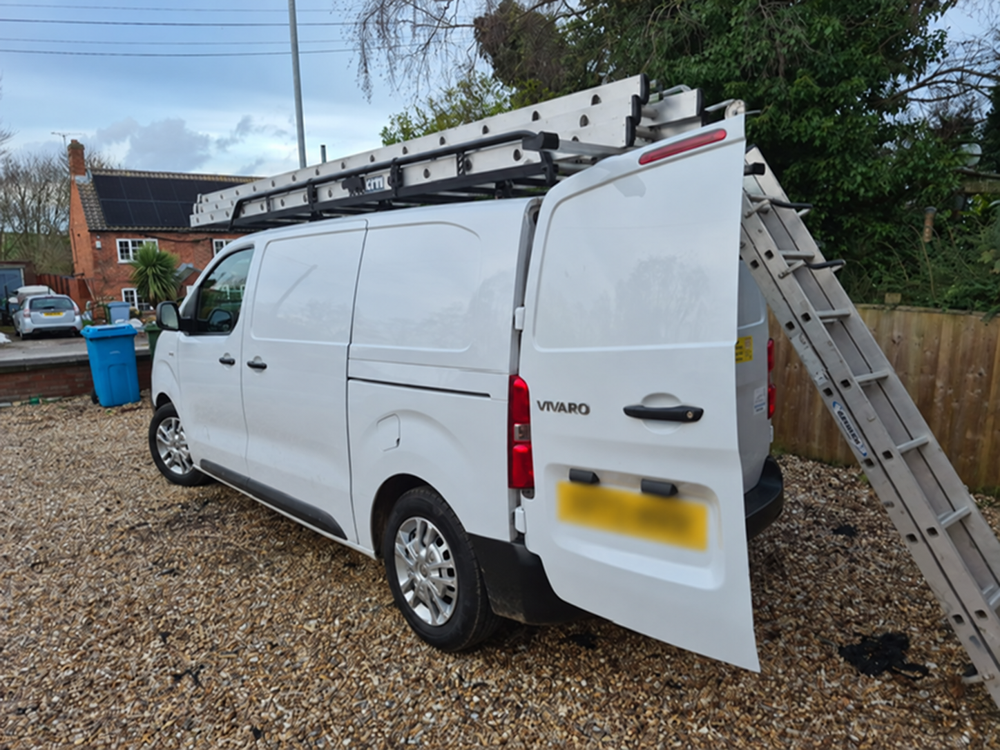 Commercial van fitted with a roof rack and rear ladder